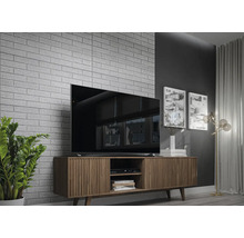 Wohnzimmer mit Fernseher auf Holzschrank vor einer Ziegelwand.