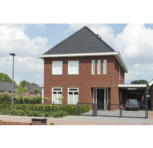 Zweckmäßiges zweistöckiges Haus mit Ziegelfassade, dunklem Ziegeldach und angrenzendem Carport.