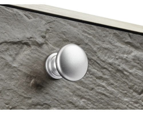 Detailansicht eines Möbelstücks mit Steinoptik und einem runden Möbelknopf