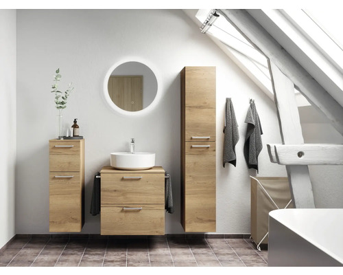 Badezimmer mit Waschtisch, Spiegelschrank, Hochschrank und Handtüchern unter einem Dachfenster.