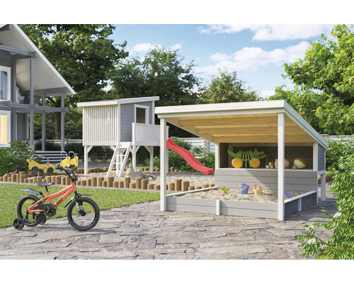 Spielplatz mit Spielhaus, Sandkasten mit Dach und Kinderfahrrad im Garten.