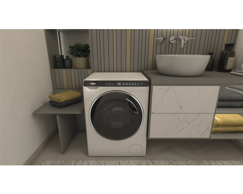 Badezimmer mit Waschmaschine, Waschbecken und Handtüchern