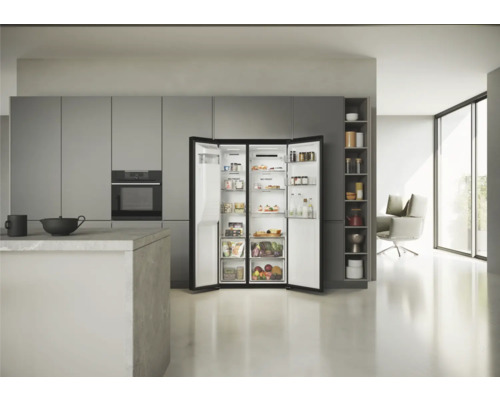 Geöffnete Kühl-Gefrierkombination in einer hellen Küche mit modernen grauen Küchenschränken