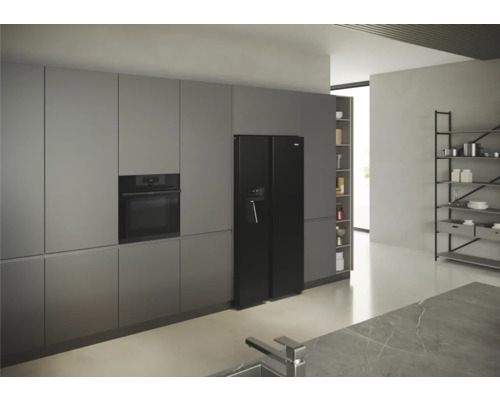 Moderne Küche mit grauen Schränken, eingebautem Ofen und schwarzem Side-by-Side Kühlschrank mit Wasserspender