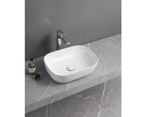 Aufsatzwaschbecken aus Keramik mit Armatur auf einer Arbeitsplatte