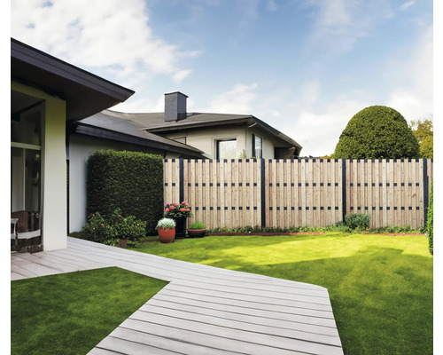 Garten mit Holzzaun, Terrasse und Rasenfläche vor Wohnhäusern