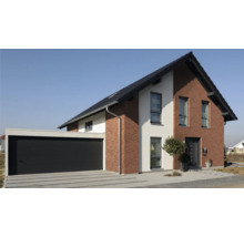Modernes Einfamilienhaus mit Garage und gepflasterter Auffahrt.