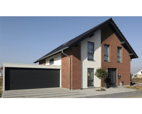 Modernes Einfamilienhaus mit Garage und gepflasterter Auffahrt.