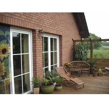Außenansicht eines Hauses mit Terrasse, Gartenmöbeln und Pflanzen