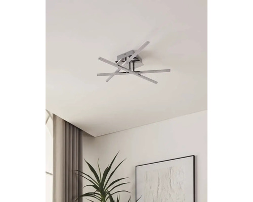 Moderne Deckenleuchte mit mehreren Armen und quadratischer Basis an einer Zimmerdecke.