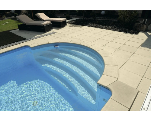 Pool mit Steintreppe und Liegestühlen im Garten