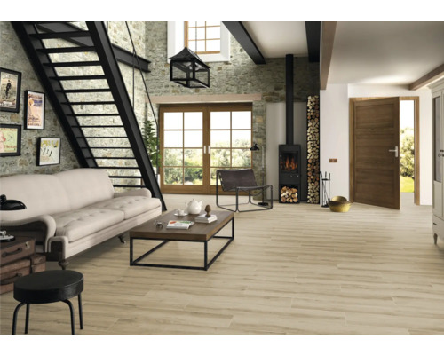 Wohnzimmer mit Steintreppe, Sofa, Couchtisch und Kaminofen auf Holzboden.