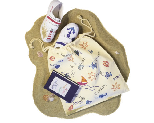 Kinderhausschuhe mit Strandmotiv, Stoffbeutel und Notizbuch auf Sand
