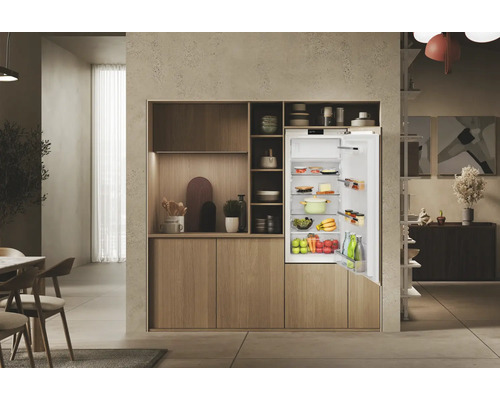 Integrierter Kühlschrank mit geöffneter Tür in einer modernen Küche mit Holzschränken