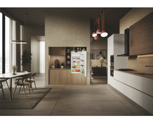 Helle Küche mit Esstisch und geöffnetem Einbaukühlschrank