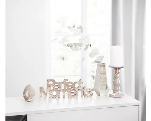 Dekoratives Arrangement mit Schriftzug, Vase und Kerze auf einem Tisch