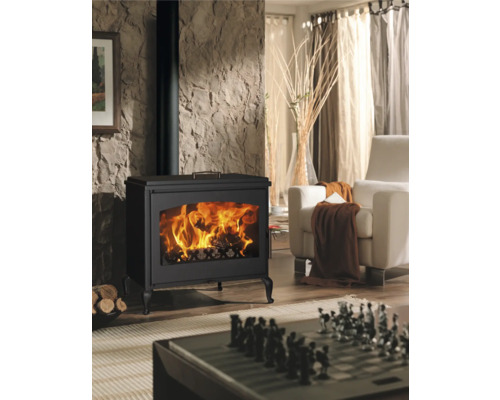 Wohnzimmer mit Kaminofen, Sessel und Schachbrett auf dem Tisch