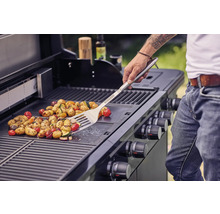 Gemüse wird mit einem Grillwender auf einem Grill zubereitet.