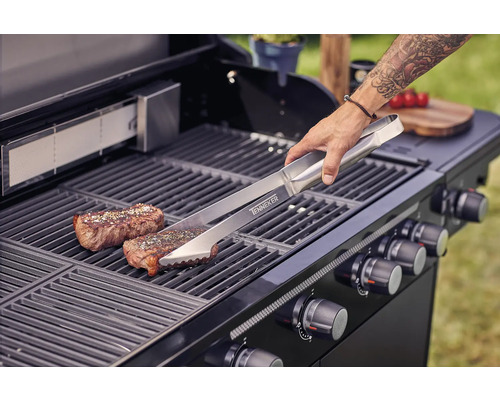 Grillszene mit Grillzange, Steak und Gasgrill