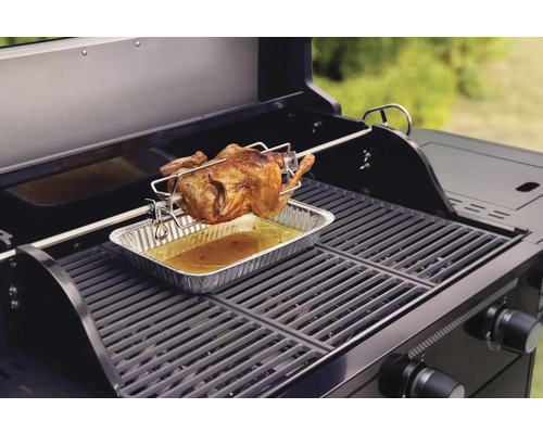 Grill mit Brathähnchen am Drehspieß über einer Tropfschale