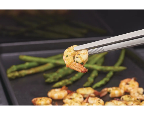 Gegrillte Garnelen mit Spargel, serviert mit Grillzange.