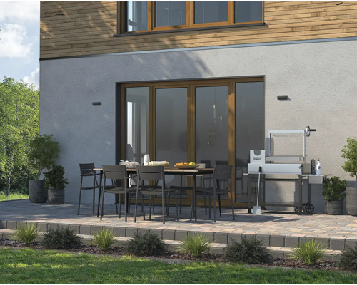 Außenbereich mit Esstisch, Stühlen und Grill vor einem Haus