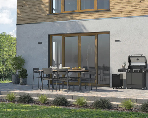 Terrasse mit Gasgrill, Gartentisch und Stühlen vor einem Haus