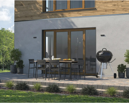 Terrasse mit Grill, Gartentisch und Stühlen vor einem Haus