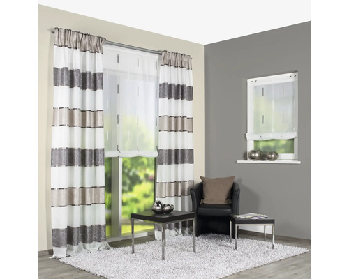 Wohnzimmer mit gestreiften Vorhängen, Rollo und Sessel auf einem Teppich