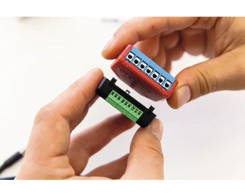 Zwei Steckverbinder werden von Händen gehalten.