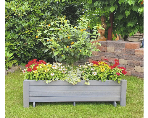 Holzblumenkasten mit Blumen im Garten.