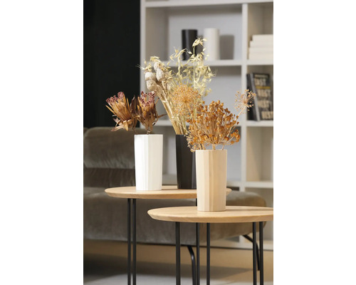 Dekorative Trockenblumen in Vasen auf Beistelltischen in einem Wohnzimmer.