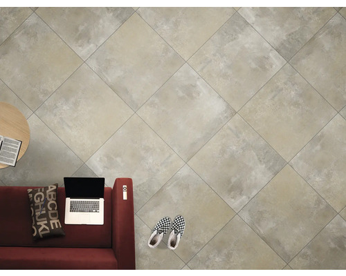 Helle Bodenfliesen in einem Wohnraum mit Sofa, Tisch und Laptop.