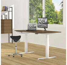 Ein höhenverstellbarer Schreibtisch mit Laptop, Monitor und Bürostuhl in einem hellen Raum.