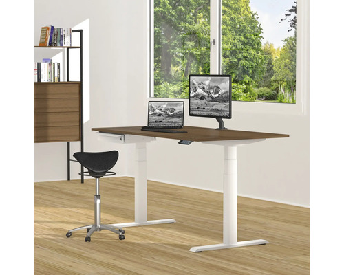 Ein höhenverstellbarer Schreibtisch mit Laptop, Monitor und Bürostuhl in einem hellen Raum.