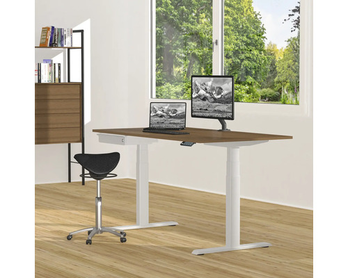 Höhenverstellbarer Schreibtisch mit Computern, Stehhocker und Bücherregal in einem hellen Raum.