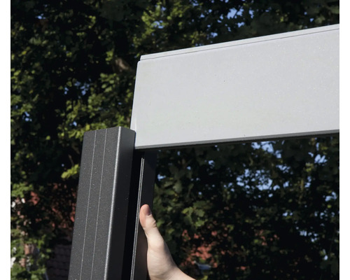 Detailansicht eines Terrassendachs mit Aluminiumrahmen und einer Person, die den Rahmen berührt.