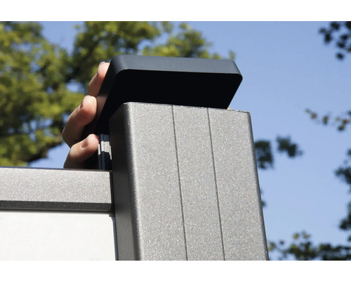 Hand setzt Abdeckung auf einen Zaunpfosten