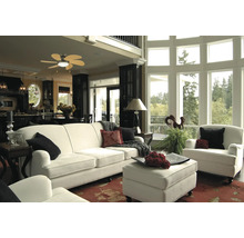 Helles Wohnzimmer mit Sofa, Sessel, Ottomane und großem Fenster