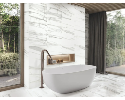 Modernes Badezimmer mit freistehender Badewanne, Armatur und Marmorfliesen.