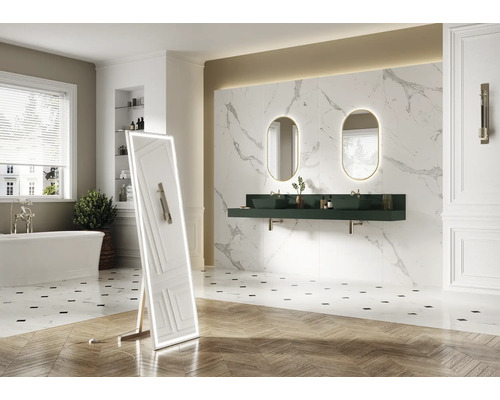 Badezimmer mit Badewanne, Spiegel, Waschtisch, ovalen Spiegeln mit Beleuchtung und Wandfliesen in Marmoroptik