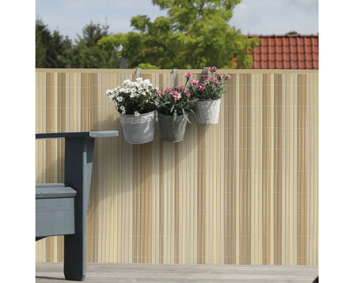 Gartenszene mit Sichtschutzzaun, Pflanzkübeln und Sitzbank