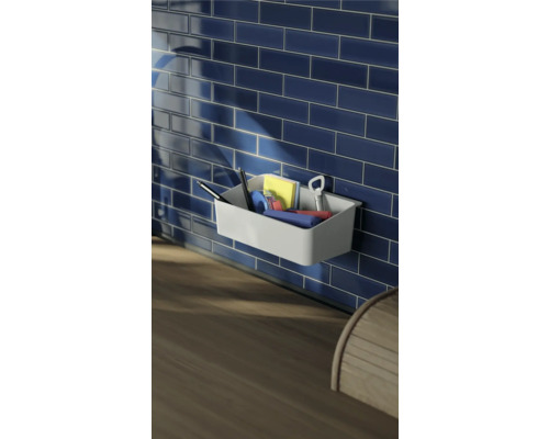 Wandablage mit Stiften, Notizen und Flaschenöffner vor blauen Fliesen