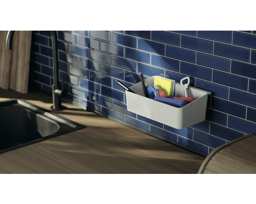 Wandkorb mit Büroartikeln vor blau gefliester Wand in der Küche