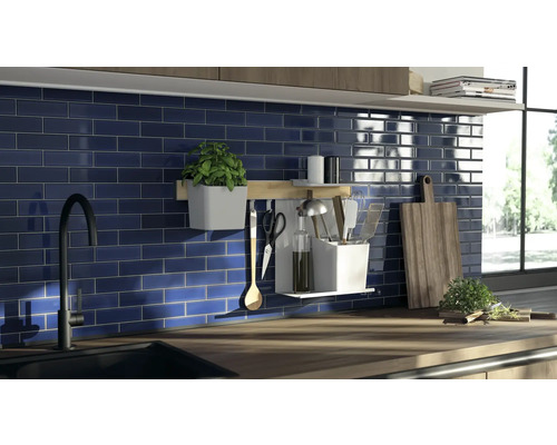 Küchenszene mit Spüle, Armatur, Fliesenwand und Küchenutensilien