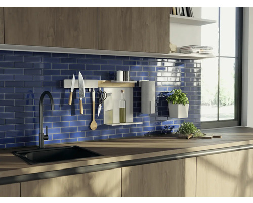 Küchenszene mit Spüle, Armatur, Küchenutensilien und blau gefliestem Hintergrund