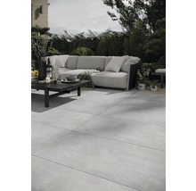 Terrasse mit großformatigen Steinzeugfliesen, Sofagarnitur und Tisch im Außenbereich.