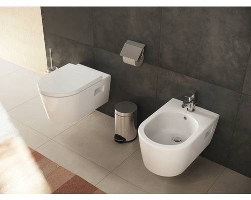 Badezimmer mit wandhängendem WC, Bidet, Toilettenbürste, Papierhalter und Abfalleimer