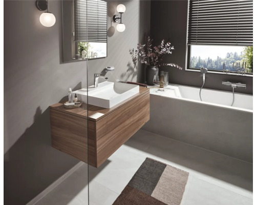 Badezimmer mit Waschtisch, Spiegel, Badewanne und Badezimmerteppich