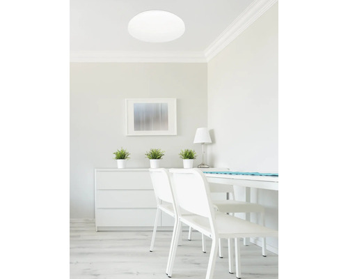 Heller Raum mit Deckenleuchte, Kommode, Tisch und Stühlen